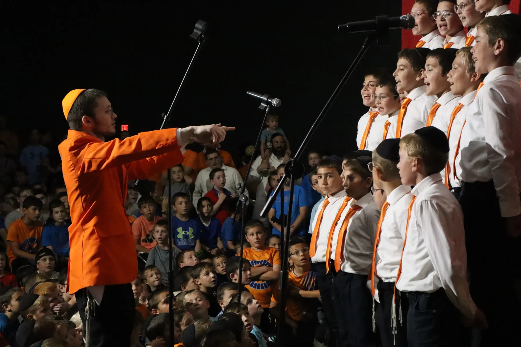Camp Chevra boys singing at an indoor performance