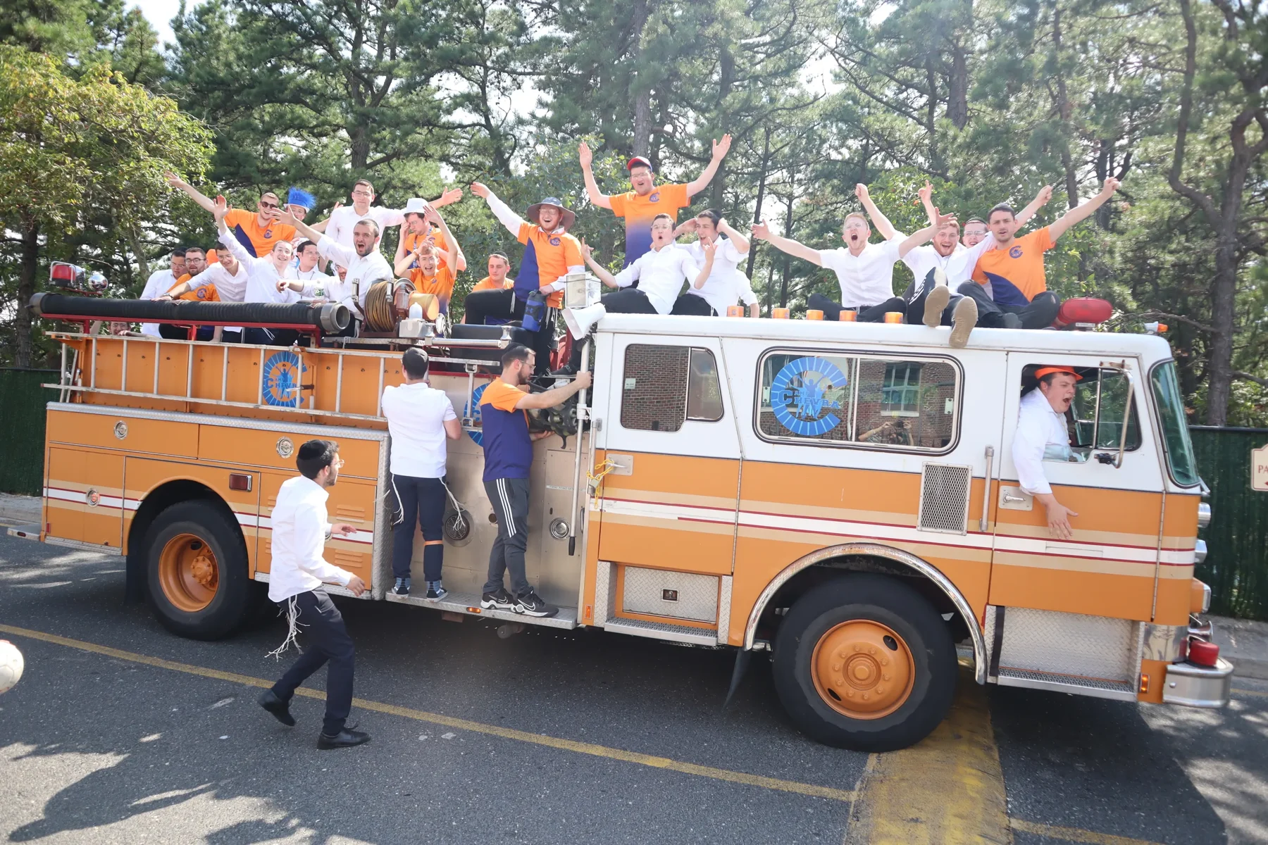 Campers waving from an orange fire truck