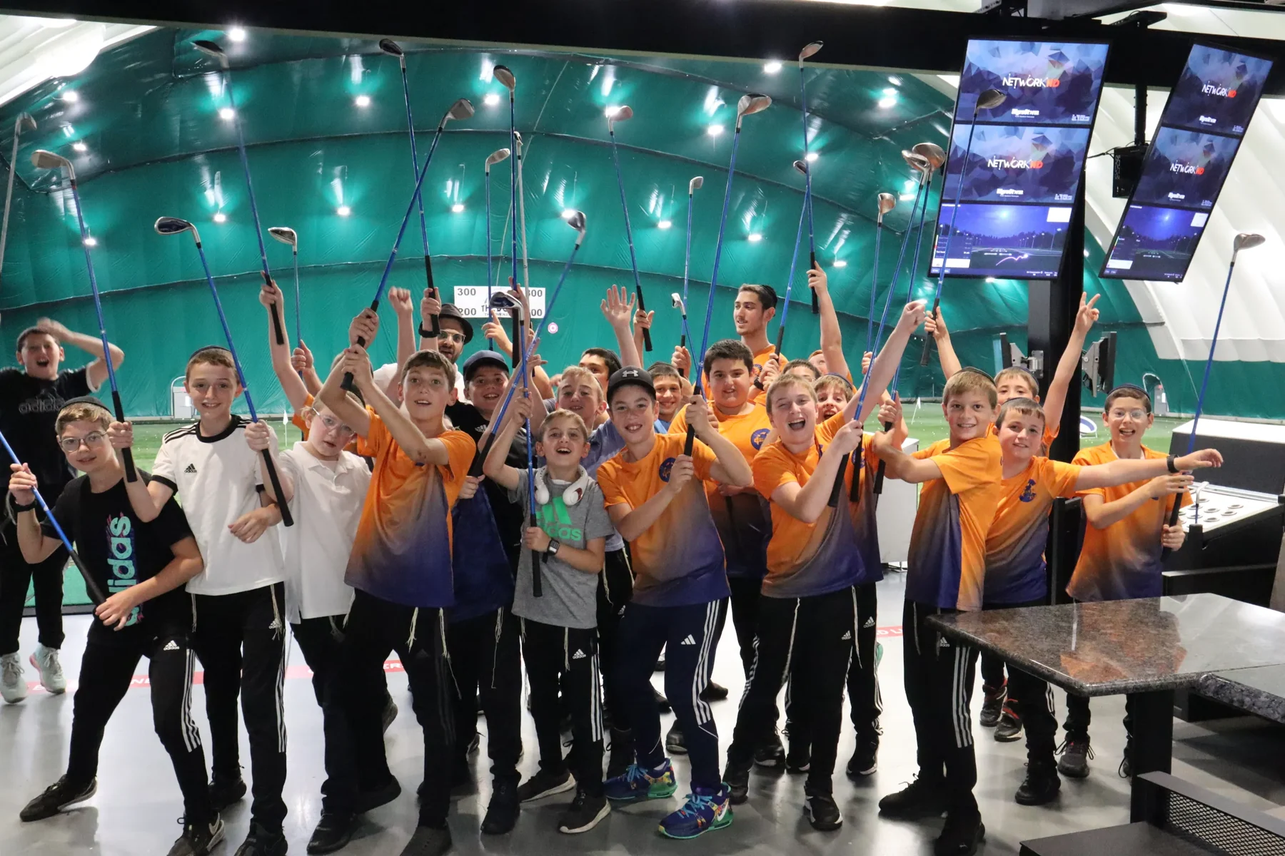 Camp Chevra group celebrating on an illuminated stage